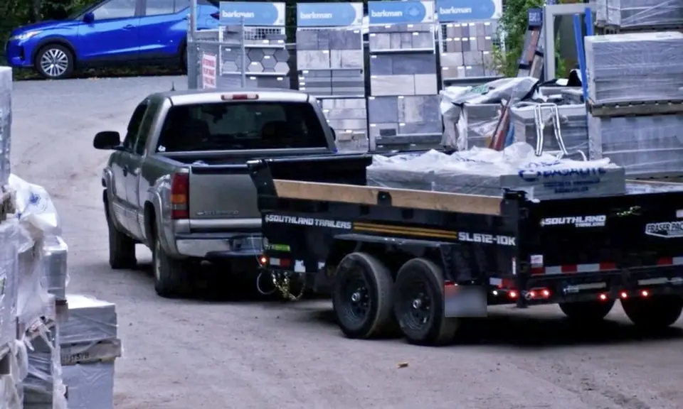 Pickup and dump trailer loaded with pallets in the yard