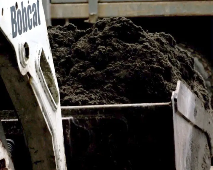 Loader with a bucket of soil